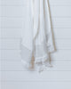 Ivory Turkish waffle bath towel with pale sage stripe hanging against white wall