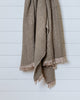 Soft khaki and beige cotton throw blanket with waffle texture and fringes