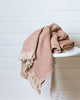 Terracotta and sand waffle-knit Turkish cotton throw folded on wooden stool
