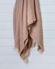 Terracotta and sand waffle-textured Turkish cotton throw hanging on white wall