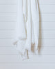 White Turkish waffle bath towel hanging on white wood panel wall