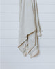 Textured ivory Turkish cotton bath towel with sauge border hanging neatly
