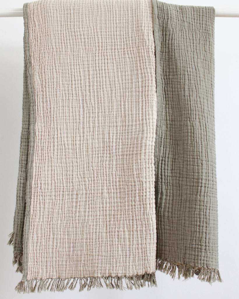 Reversible olive and ecru muslin cotton throw with soft crinkled texture and fringed edges