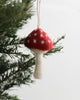 mushroom ornament in red and cream hanging on Christmas tree branch, handmade decor