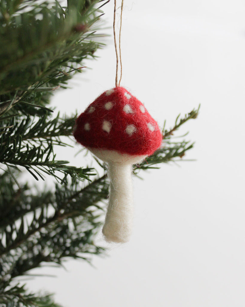 mushroom ornament in red and cream hanging on Christmas tree branch, handmade decor